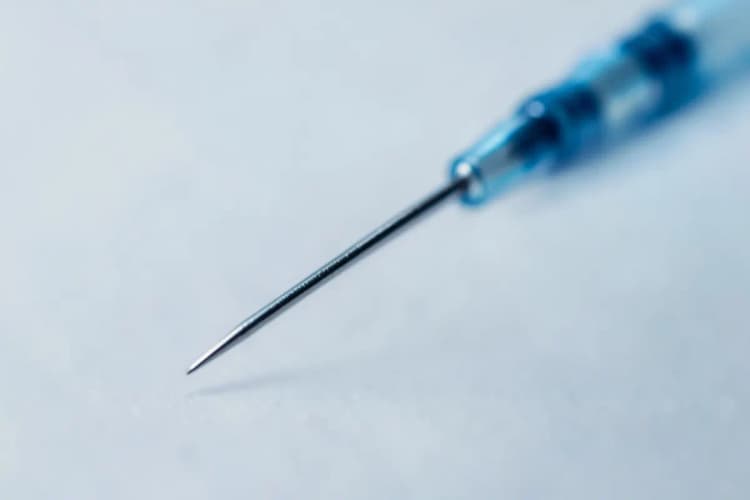 Agulha fina de mesoterapia capilar em close-up, pronta para aplicação.